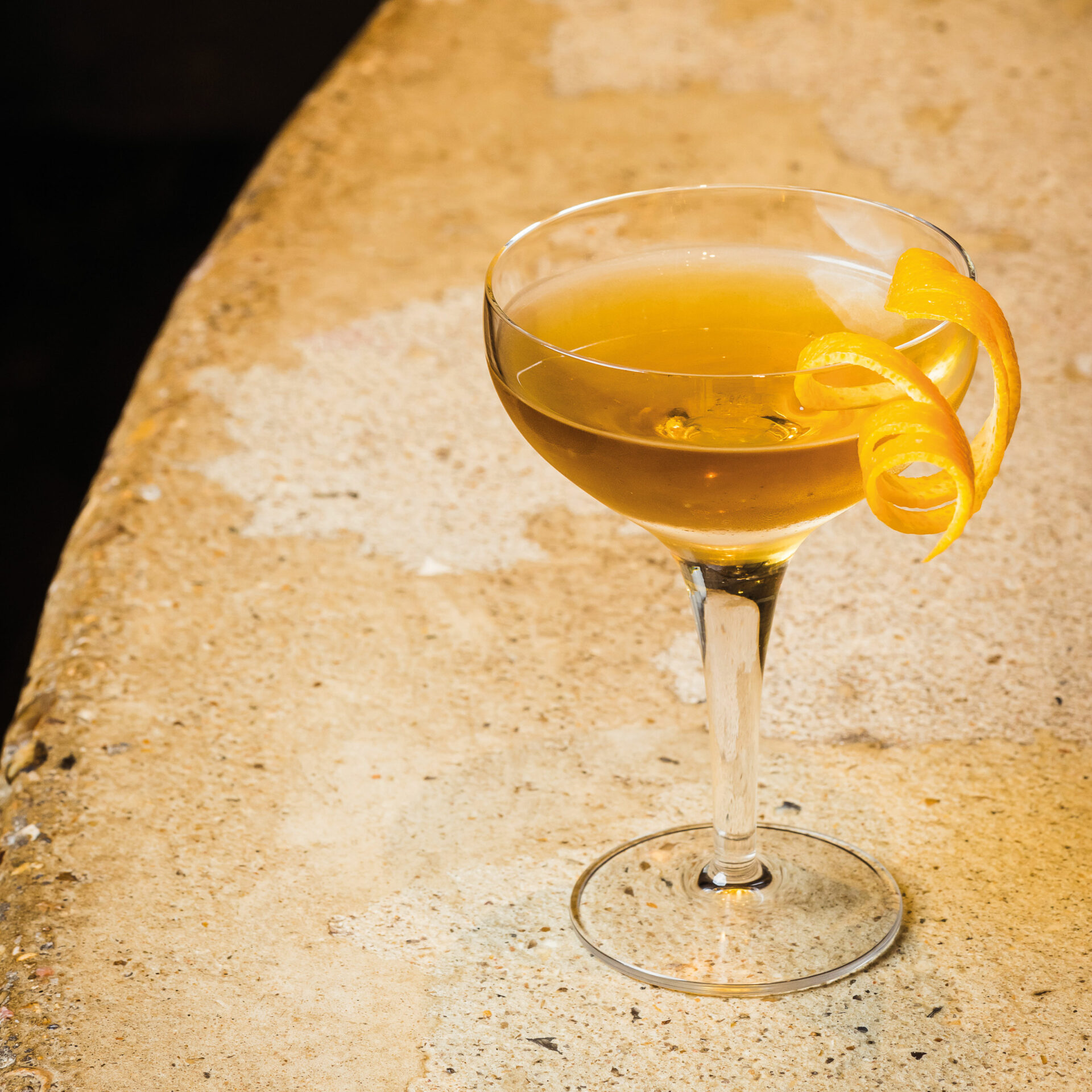 Cocktail jaune au citron présenté avec une rondelle de citron torsadée